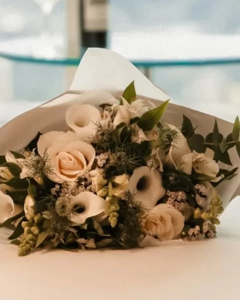 Ramo de rosas y calas blancas sobre cama de suite en BINN Hotel, detalle de bienvenida para el Día de las Madres en Medellín.