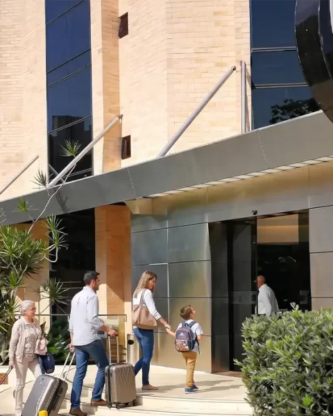 Familia llegando con maletas a la entrada de BINN Hotel, viaje familiar en Medellín en mayo.