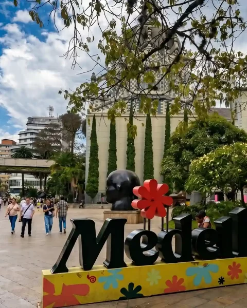 Plaza Botero de Medellin con letrero emblematico de la ciudad y Palacio de la Cultura al fondo.