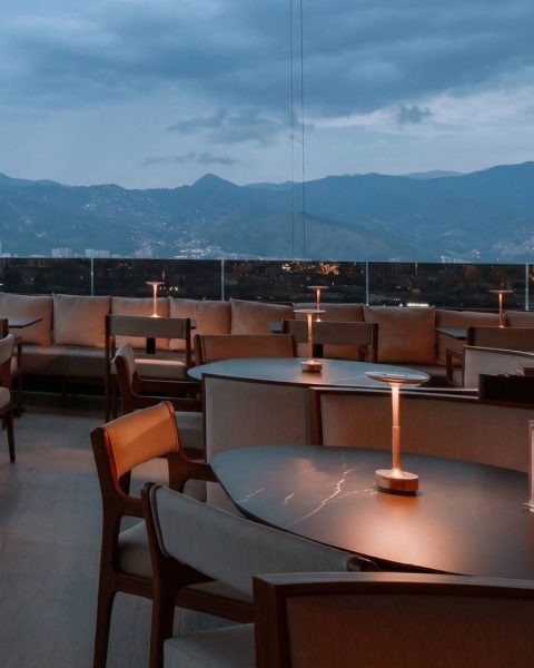 Brunch con vista panorámica a las montañas de Medellín en Etro Rooftop con ambiente elegante y mesas iluminadas al atardecer
