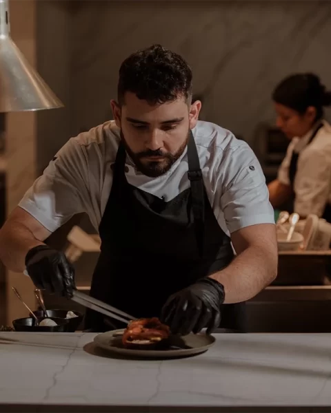 Chef de La Makha emplatando un plato en la cocina del restaurante en Medellín