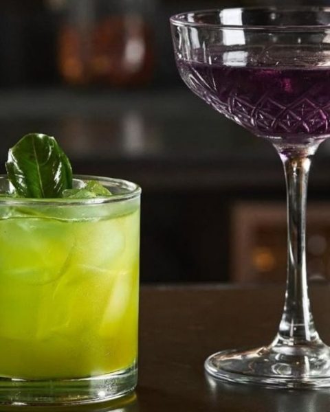 Dos cócteles caseros de La Makha sobre la barra, decorados con una hoja verde fresca.