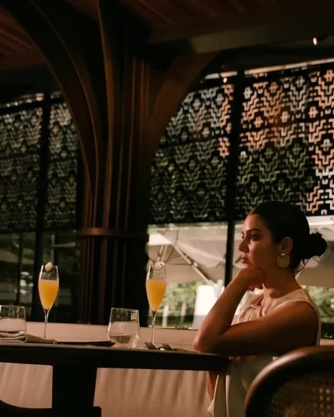 Mujer disfrutando de una experiencia de comer solo lujo en Medellín dentro de un La Makha restaurante de diseño elegante.