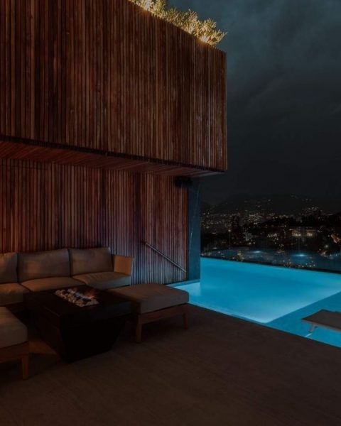 Área de piscina y lounge iluminada por la noche, con un diseño íntimo de Etro que invita a la relajación