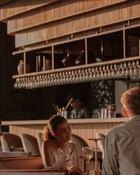 Grupo en sofás con vino blanco en el interior del bar de ETRO Rooftop, cita de mayo en BINN Hotel Medellín.
