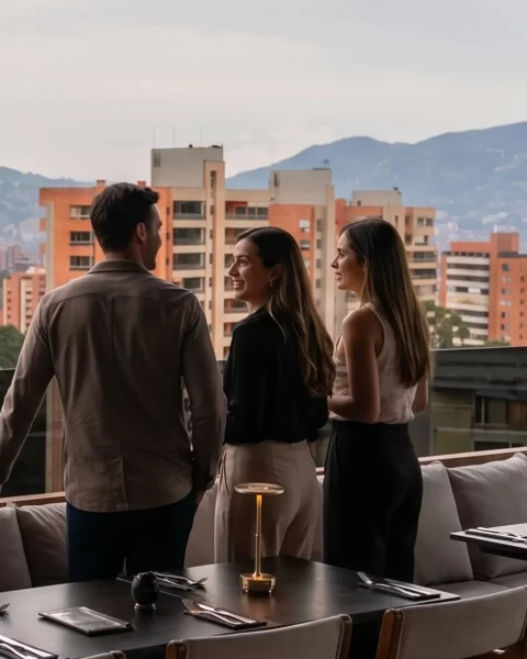 Tres visitantes descubriendo la terraza de ETRO Rooftop con vista a El Poblado de día, guía para novatos en BINN Hotel Medellín.