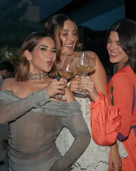 Tres mujeres brindando con copas de vino en la terraza de Etro Rooftop de Binn Hotel en Medellín.