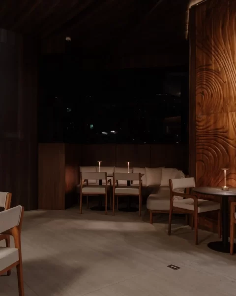 Salón interior de Etro Rooftop en Binn Hotel con panel de madera tallada y vista nocturna a Medellín