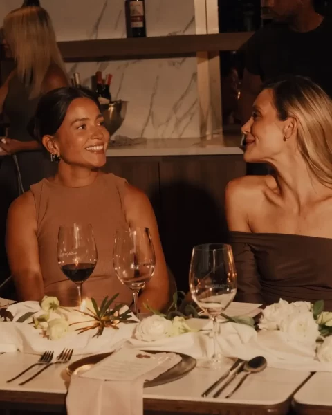 Hija y madre disfrutando experiencias para mamá; cena gourmet con copas de vino tinto en restaurante La Makha.