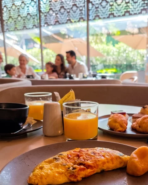 Familia desayunando en el salón de La Makha con vista al jardín