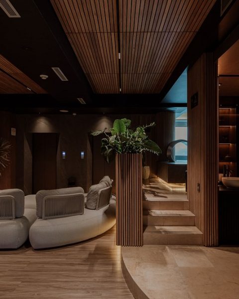 Lobby minimalista de madera y vegetación en Binn Hotel de lujo eco-friendly en Medellín con diseño orgánico.