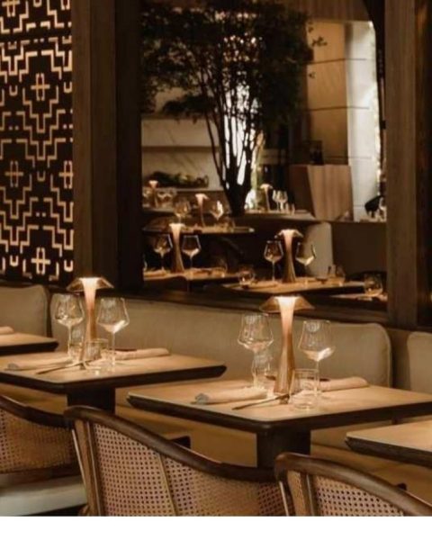 Restaurante La Makha con mesas y sillas frente a una gran ventana.