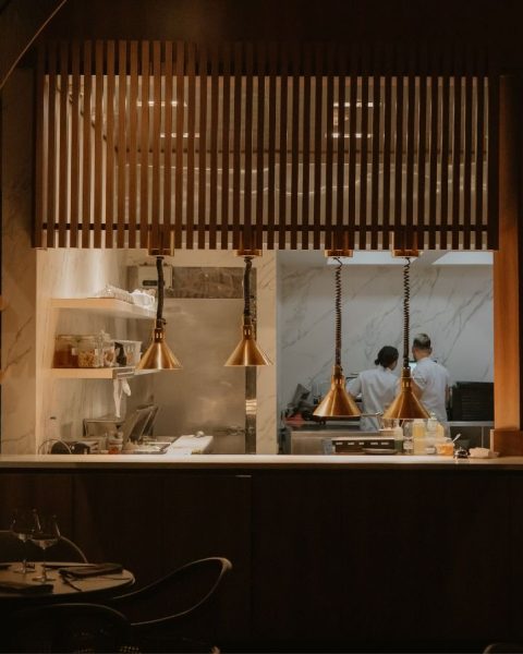 Restaurante La Makha con paredes de madera y una ventana, ofreciendo un ambiente acogedor y fusion culinaria.