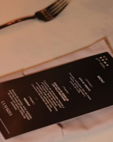 Menú de boda de lujo sobre una mesa, acompañado de un tenedor y un cuchillo elegantes