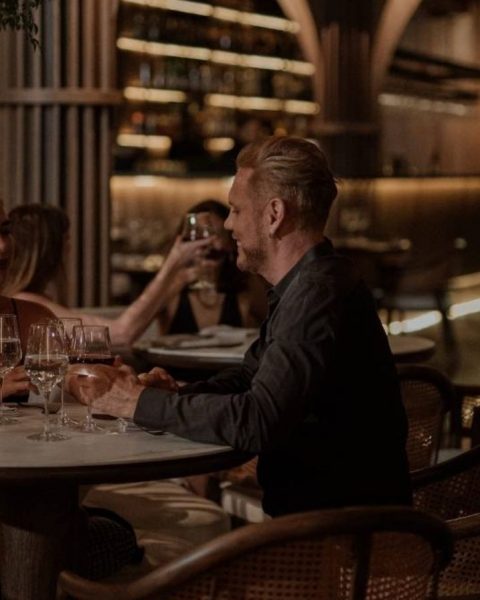 Pareja sentada en una mesa de restaurante, disfrutando de una cena romántica en Medellín