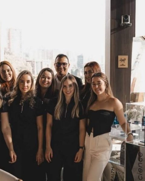 Grupo de personas sonriendo para la foto frente al edificio de Etro Rooftop, celebrando en la Reserva VIP