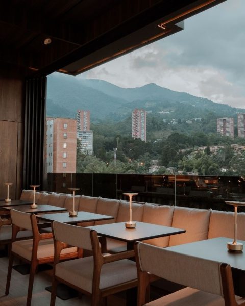 Vista de un restaurante que combina montañas y la ciudad, ofreciendo un ambiente acogedor y vistas impresionantes