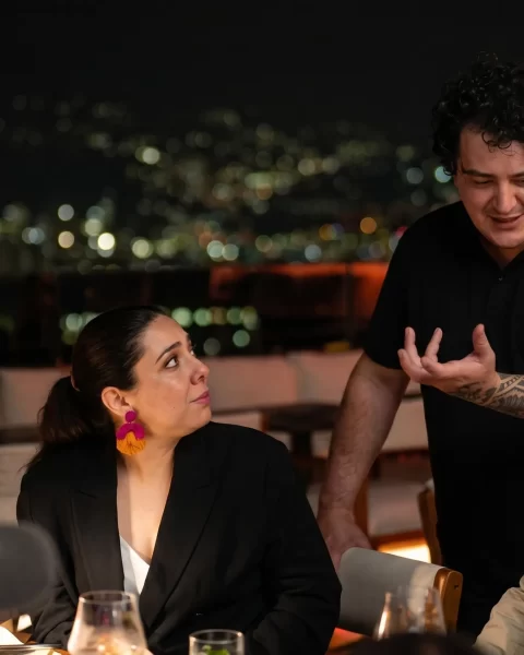 Chef David Suárez atendiendo comensales en terraza nocturna de La Makha con vista a Medellín