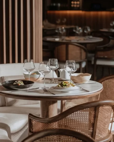 Mesa elegante con platos gourmet y sillas de mimbre, reflejando las tendencias gastronómicas 2026 en Medellín.