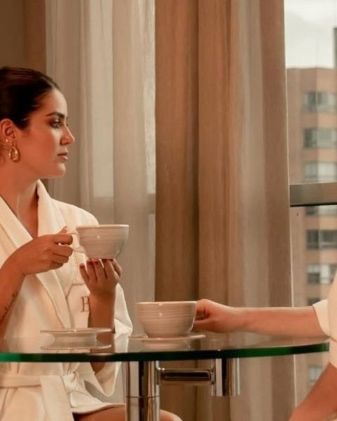 Dos mujeres en batas sentadas a una mesa, disfrutando de una taza de té en un ambiente de bienestar y lujo